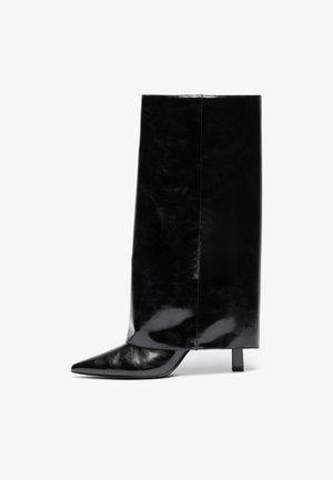 Botín de cuero negro hasta el tobillo con punta afilada y tacón cuadrado, que presenta un caña alta y brillante y un acabado texturizado en la parte inferior.