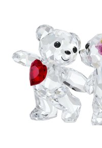 Kristallfigurer av två björnar, en som håller ett rött hjärta, med klara och fasetterade ytor, runda öron och svarta ögon.