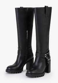 Stivali in pelle nera al ginocchio con tacco a blocco spesso, cerniera laterale e cinturino con borchie sulla caviglia. Tessuto liscio e design elegante.