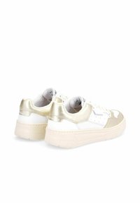 Zapatillas blancas con acentos dorados, que presentan una suela gruesa, paneles metálicos texturizados y detalles perforados en los laterales.