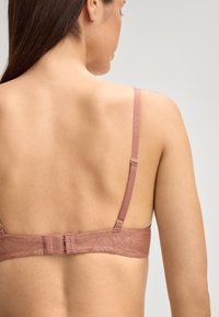 Reggiseno in morbido tessuto rosa con motivo floreale, dotato di bretelle regolabili e chiusura con ganci e occhielli sul retro.