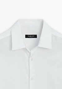 Witte katoenen overhemd met een klassieke kraag, een knoopsluiting aan de voorkant en een zwart label met de tekst "Massimo Dutti." Soepele textuur, slim fit ontwerp.