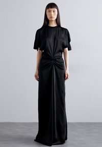 Zwarte maxi-jurk met korte pofmouwen, geraffineerd in de taille, gladde textuur en een vloerlange ontwerp. Minimalistische stijl tegen een eenvoudige achtergrond.