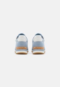 Des chaussures bleu clair avec une tige en daim, des accents blancs au talon et un détail en liège texturé au talon pour une meilleure adhérence et un soutien.