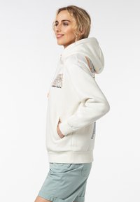 Off-white hoodie met een trekkoord, voorzakken en zijbranding in kleurrijke tekst. Geribde boorden en zoom; zachte, gestructureerde stof.