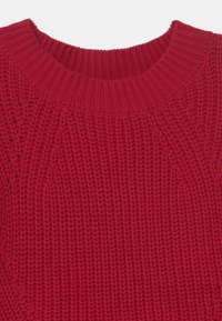 Maglione rosso lavorato a maglia con scollo tondo a coste e motivo testurizzato, caratterizzato da un tessuto spesso e morbido di colore uniforme.