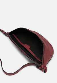Borsa a tracolla in pelle rossa con chiusura a zip. Presenta un esterno liscio, una fodera interna nera e una tracolla piatta con accessori regolabili.