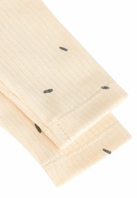 Beige geribbelde sokken met kleine zwarte stippen, met een gladde textuur en een omgevouwen boord aan de bovenkant. Zachte stofsamenstelling.
