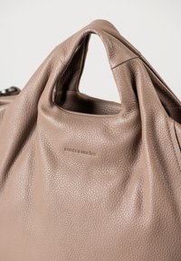 Borsa in pelle pebble color talpa con manico corto e logo "aunts & uncles" embossato su sul davanti.