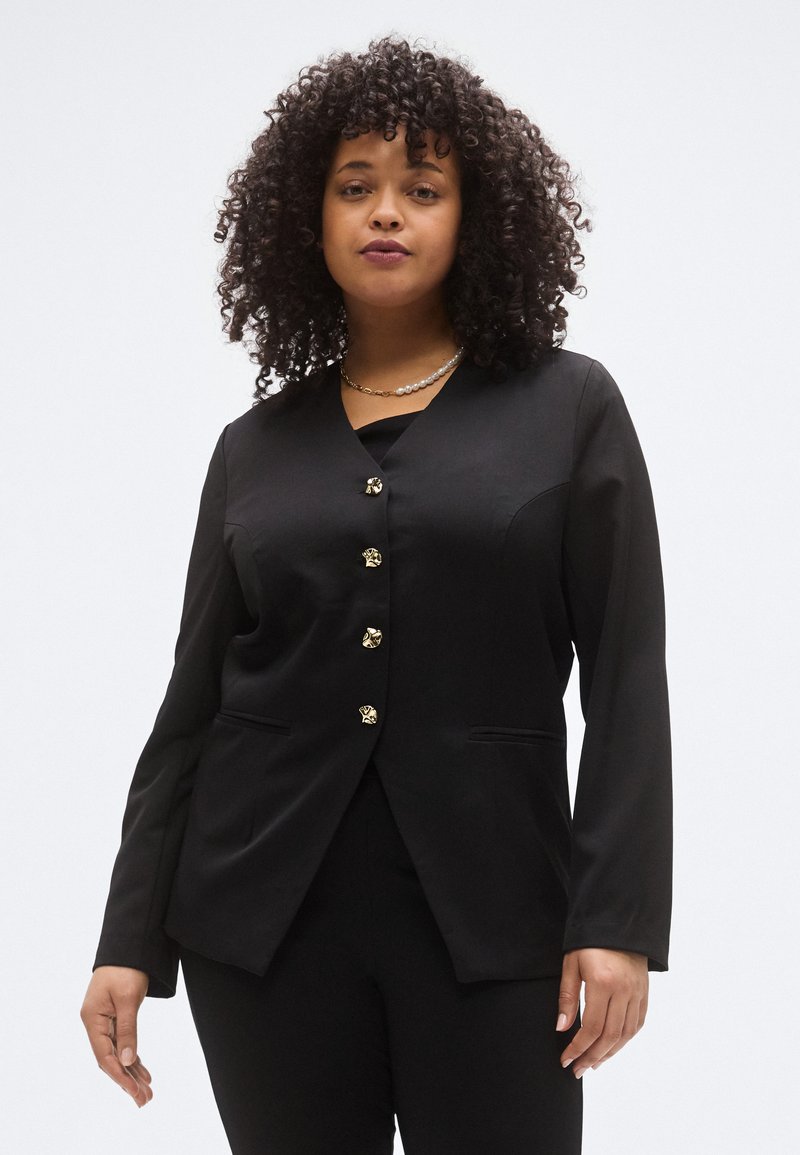 Fekete, szabott blézer V-nyakkivágással, arany díszgombokkal és két elülső zsebbel. Hosszú ujjú, sima szövettextúrájú.