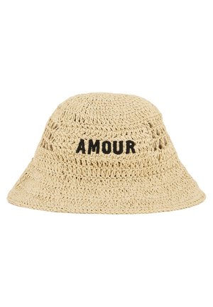 Bob beige en crochet avec le mot "AMOUR" brodé en noir sur le devant, présentant de petits trous d'aération autour de la calotte.