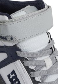 Αθλητικά παπούτσια υψηλής μπάντας σε γκρι, λευκό και ναυτικό. Διαθέτουν υφαντό δέρμα, λεπτομέρειες από πλέγμα, μαξιλαρωμένο κολάρο και γκρι κορδόνια. Λογότυπο στο πλάι.