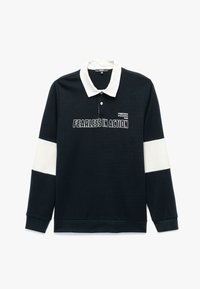 Polo de manga larga en color azul marino con cuello blanco y acentos en las mangas. Presenta un texto gráfico en negrita que dice "SIN MIEDO EN ACCIÓN" en la parte frontal. Tejido suave.