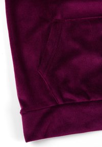 Dopasowana, prążkowana fioletowa bawełniana tkanina z kieszenią kangurzą i mankietem u dołu. Gładka tekstura o jednolitym kolorze i wzorze.
