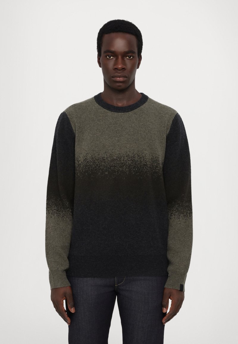 Pulover din tricot cu un design ombre, trecând de la nuanțe de verde la bleumarin închis, guler rotund și mâneci lungi. Textură moale, detalii minimale.