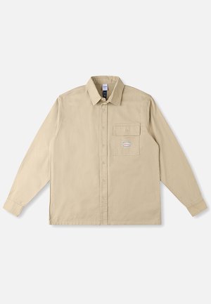 Beige shirt met lange mouwen van katoenen stof, voorzien van een klassieke kraag, knoopsluiting aan de voorkant, een borstzak en een merkpatch op de zak.