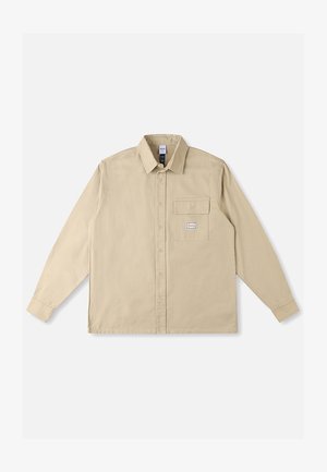 Beige shirt met lange mouwen van katoenen stof, voorzien van een klassieke kraag, knoopsluiting aan de voorkant, een borstzak en een merkpatch op de zak.