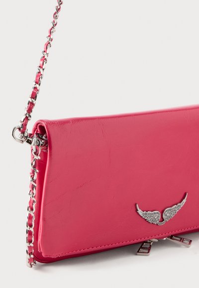 Φούξια δερμάτινο clutch με ασημένιο αλυσίδα ιμάντα, διακοσμημένο με μικρή ασημένια λεπτομέρεια σε σχήμα φτερού στην εμπρόσθια πτέρυγα.