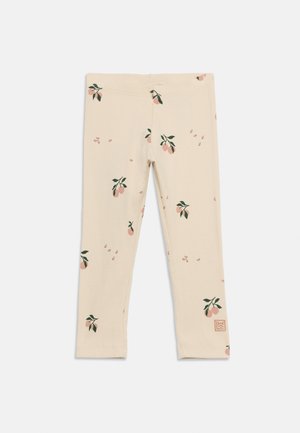Børneleggings i cremefarve med små pink frugter og grønne bladmønstre, med et firkantet mærkepatch nær kanten.