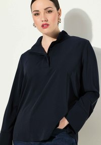 Marine pullover shirt met een half-rits kraag, losse fit en lange mouwen. Zachte, gladde stof met een subtiele glans. Split zoom detail.