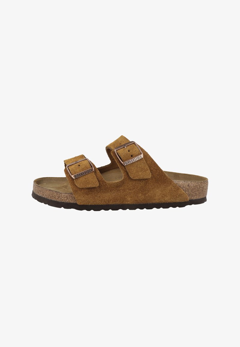 Sandale Birkenstock en daim marron avec deux brides à boucle réglables et semelle en liège sur fond blanc.