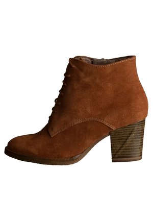 Brun ruskindsstøvle til anklen med snørelukning foran og stablet blokhæl, sideprofil på hvid baggrund.