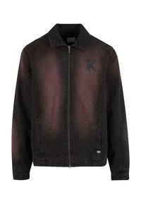 Sort denimjakke med glidelås, mørk gradientfarge, spiss krage og en teksturert bokstav "K"-lapp på brystet. Lange ermer, sidelommer.
