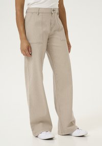Wide-leg trousers in beige with vertical stripes, made from textured fabric. Features front pockets and a button closure at the waist.