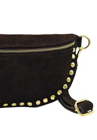 Sac en daim marron avec une fermeture éclair dorée et des clous dorés décoratifs le long du bord. Il possède une bandoulière réglable avec une boucle en métal.