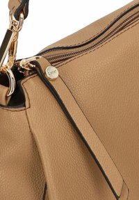 Taschen aus strukturiertem, braunem Leder mit goldenen Beschlägen, ausgestattet mit einem Reißverschluss und einem auffälligen Gabor-Logo am Reißverschlussanhänger. Sichtbare schwarze Akzentdetails.
