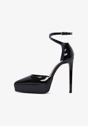 Black patent leather high-heeled shoes with a pointed toe, platform sole, and an ankle strap. Glossy finish with a stiletto heel.