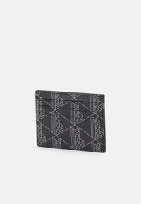 Porta-cartões preto feito de material texturizado, apresentando um padrão geométrico branco. Possui múltiplos compartimentos para cartões e um design elegante.