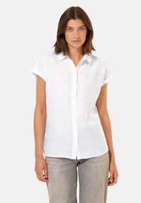 Camicia bianca di lino a maniche corte con bottoni sul davanti e colletto. Presenta polsini arrotolati e una vestibilità rilassata.
