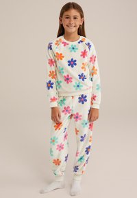 Fleece loungekläder set som har en krämfärgad bakgrund prydd med flerfärgade blommönster i orange, blått, rosa och grönt.