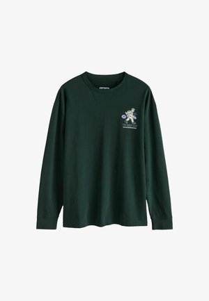 Sötétzöld, hosszú ujjú póló, pamutból készült. Bal oldalon grafikus nyomtatással, amely egy karaktert és szöveget ábrázol.