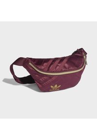 Burgundy textile fanny pack with a quilted pattern, gold zipper, and gold logo. Features an adjustable strap for secure wear.
