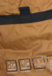 Water-repellent, wind-resistant brown fabric with a smooth texture; features icons for functionality and sustainability.