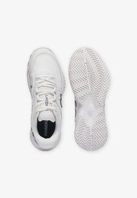 Scarpe sportive bianche con una parte superiore in mesh testurizzato, dettagli in nero sul logo e una suola in gomma a motivi con un design a spina di pesce.