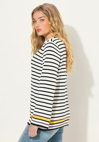 Maglione a righe in crema con linee blu navy, con dettagli viola e gialli all'orlo. Materiale a maglia morbido con una vestibilità comoda.