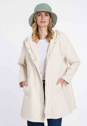 Helle beige, knielange Regenjacke mit Kapuze, Druckknöpfen, zwei Seitentaschen und lockerer Passform, kombiniert mit einem mintgrünen Bucket Hat.