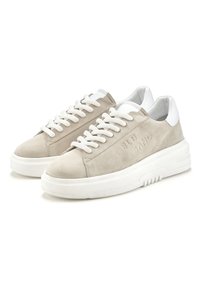 Sneaker beige in suede con dettagli in pelle bianca, suola in gomma bianca spessa e lacci testurizzati. Testo incavato sul lato.