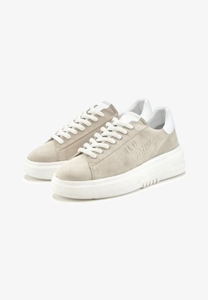 Beige Wildleder-Sneaker mit weißen Lederakzenten, dicker weißer Gummisohle und strukturierten Schnüren. Prägung auf der Seite.