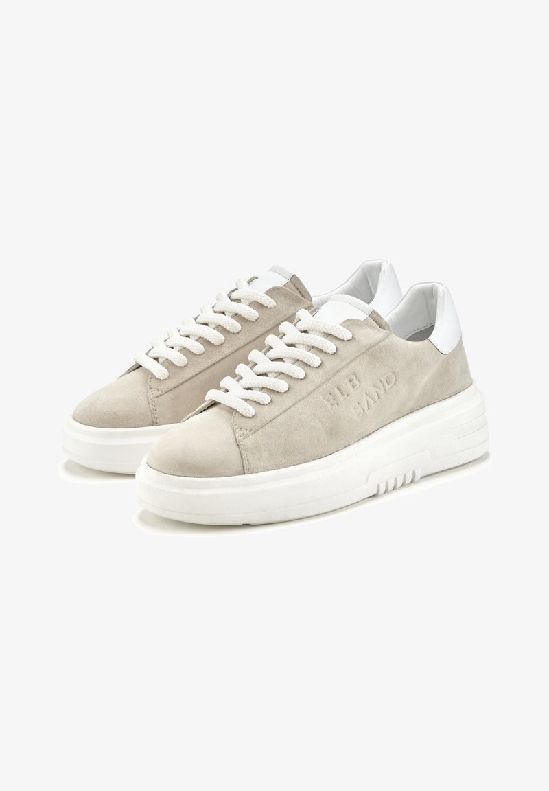 Beige nubukist sneakers valgete nahka aktsentidega, paksu valge kummist tallaga ja tekstuursete paeltega. Külje peal on sisse pressitud tekst.