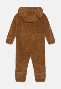 Brązowy kombinezon z polaru z kapturem, wyposażony w okrągłe uszy, długie rękawy i elastyczne mankiety. Miękka tekstura i bezszwowy tył.