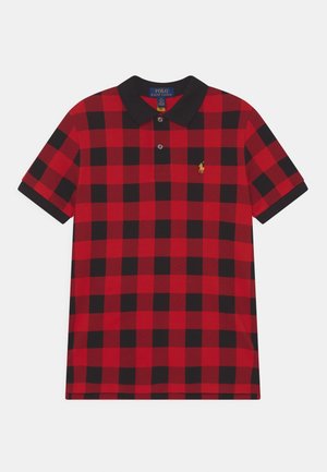Polo shirt quadrillé rouge et noir avec un col noir, doté de trois boutons et d'un petit logo jaune sur la poitrine gauche. Tissu en coton.