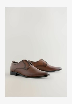 Brown leather dress shoes with a smooth finish, pointed toe, and lace-up design. The sole is black with a slight sheen.
