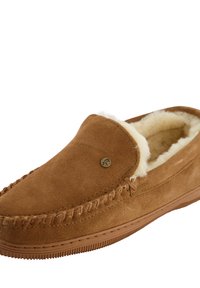 Bruine suède slippers met een zachte crèmekleurige schapenvachtvoering, gestikte details en een rond logoaccent aan de bovenkant. Rubberen zool en instapontwerp.