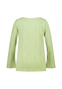 Langarmtop in lichtgroen, met een golfpatroon textuur. Eenvoudige ronde halslijn, losse pasvorm en gladde stof.