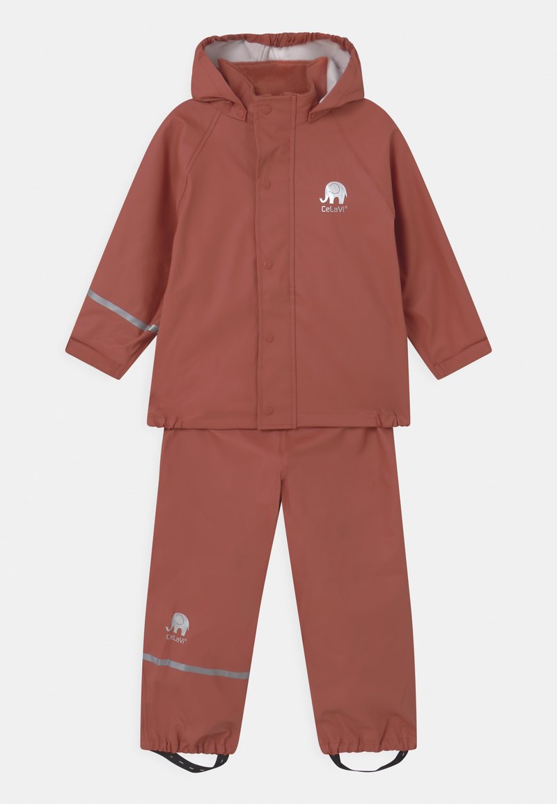Vodoodporna dvodelna dežna obleka v rdečkasto rjavi barvi. Jakna s kapuco in zapiranjem na pritiske, srebrni odsevniki ter elastični manšeti, v kompletu z usklajenimi hlačami.