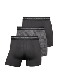 Tres pares de calzoncillos de hombre en negro y gris. Con una cinturilla con logo y una tela lisa y elástica con diversas texturas y patrones.